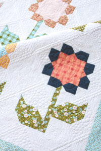 Cottage Blossoms flower quilt PDF pattern by Lella Boutique. Make it with a layer cake or fat quarters. Fabric is Little Miss Sunshine by Lella Boutique for Moda Fabrics. Gorgeous custom quilting by Natalia Bonner.