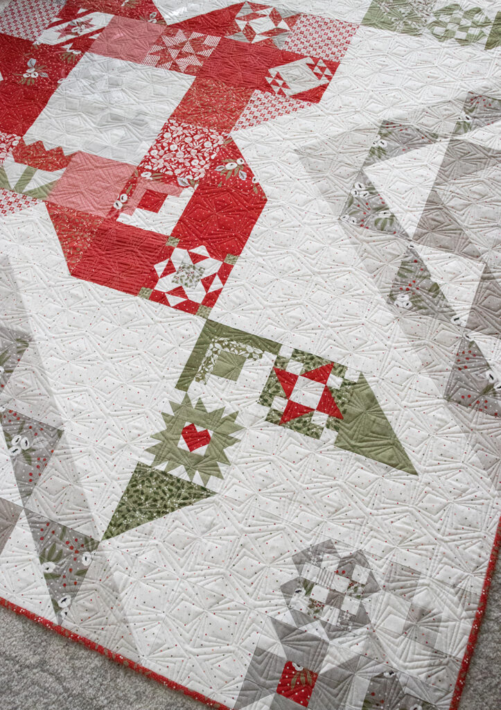 Rose in Bloom quilt in Christmas Morning fabric by Lella Boutique. Vanessa plugged in the Sewcialites sampler blocks into the Rose in Bloom quilt layout.