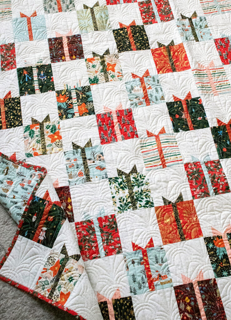 Gift Swap Christmas present quilt by Lella Boutique. Fabric is Holiday Classics by RIfle Paper Co for Cotton + Steel. Make it with charm packs, layer cakes, or fat quarters!