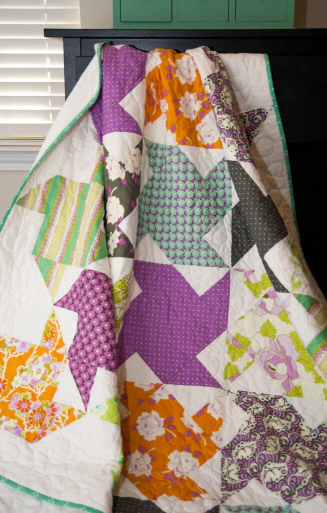 Twirl pinwheel quilt by Lella Boutique. Beginner friendly quilt using fat quarters, fat eighths, or Layer Cakes! Fabric is "Lottie Da" by Heather Bailey.