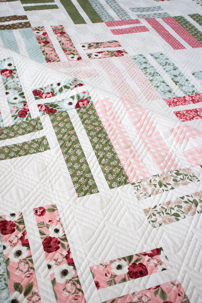 "Stairway to Heaven" jelly roll quilt by Lella Boutique. Beginner friendly geometric quilt in Lovestruck fabric. Download the pattern here.