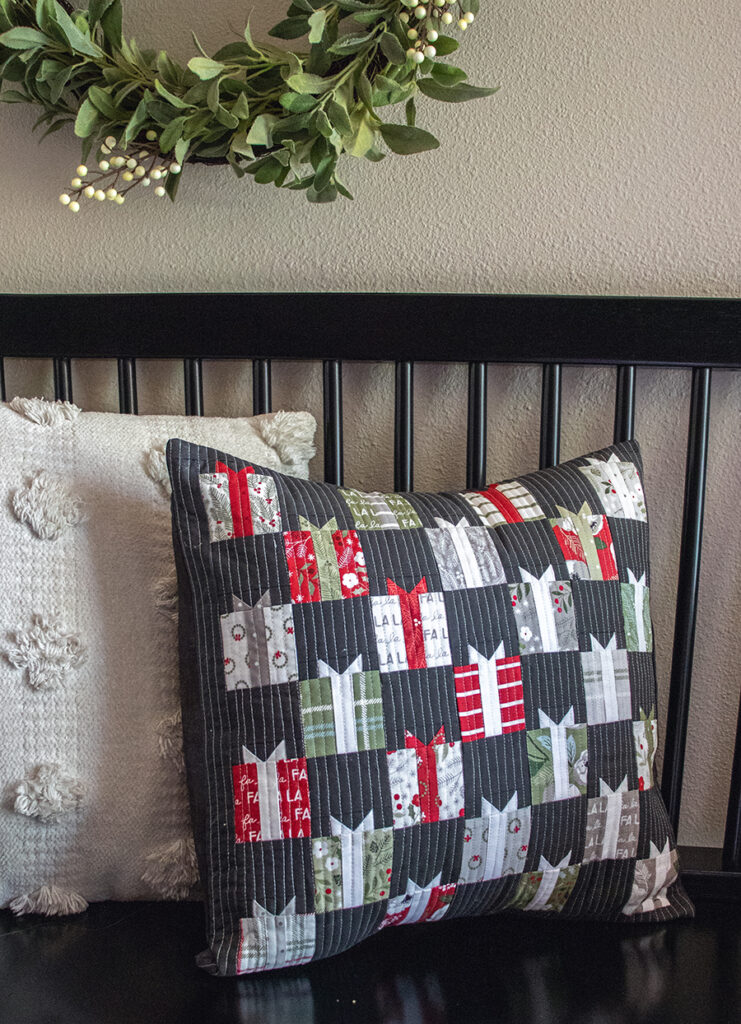 FREE Giving Season pillow pattern by Vanessa Goertzen of Lella Boutique for Moda Fabrics. Cute little Christmas present quilt made using a mini charm pack of Christmas Eve fabric. Download the free PDF here!