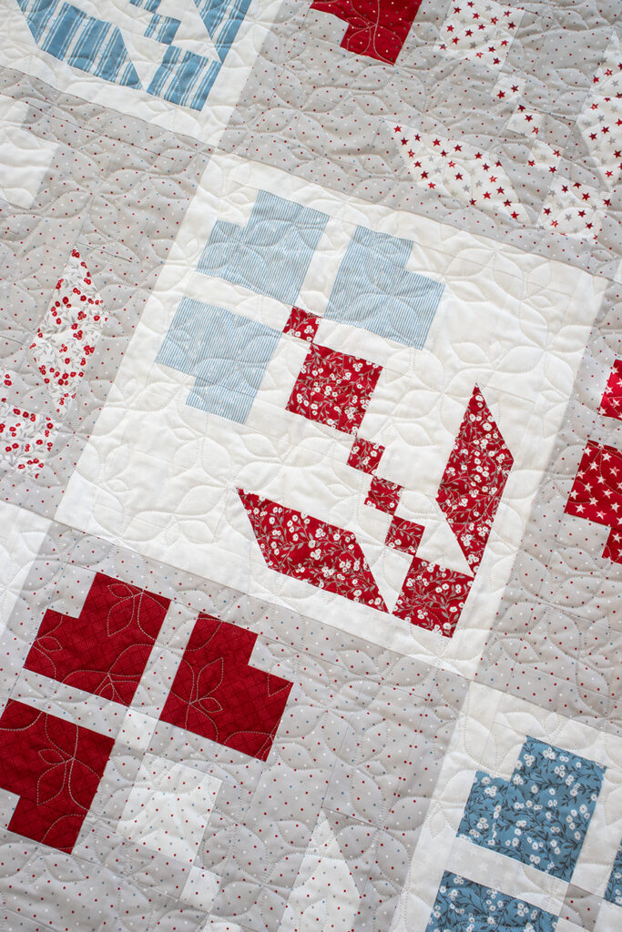 Red White & Bloom 4th of July flower quilt by Vanessa Goertzen of Lella Boutique. Fabric is Old Glory by Lella Boutique for Moda Fabrics (Feb 2024). Make it with fat eighths.