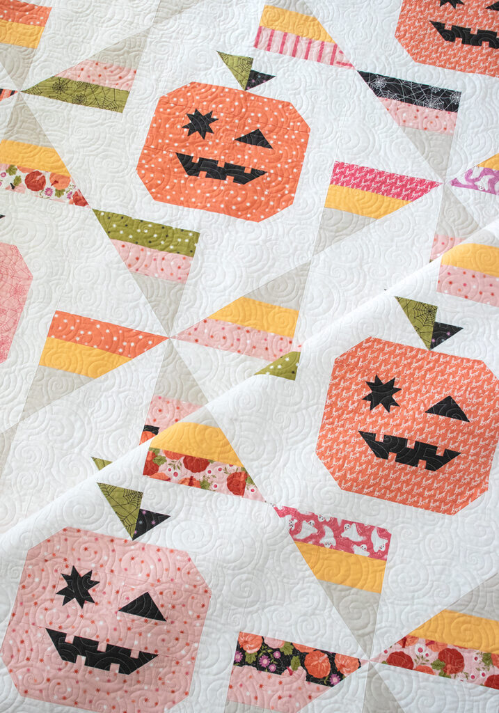 Tricks & Treats pumpkin & candy corn quilt by Lella Boutique. Cute little winking Jack-o-lantern quilt blocks in Hey Boo fabric by Lella Boutique for Moda Fabrics coming April 2024. Download the PDF here!