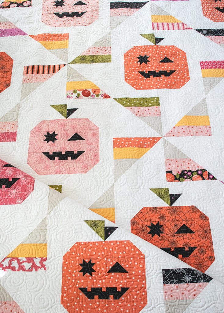 Tricks & Treats pumpkin & candy corn quilt by Lella Boutique. Cute little winking Jack-o-lantern quilt blocks in Hey Boo fabric by Lella Boutique for Moda Fabrics coming April 2024. Download the PDF here!