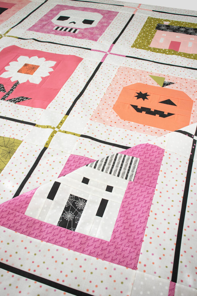 the Monster Mash sampler quilt by Lella Boutique. Cute Halloween block of the month with haunted house, skull, Frankenstein, pumpkin, ghost, and haunted daisy patchwork blocks. Fabric is Hey Boo by Lella Boutique for Moda Fabrics (April 2024). Quilt Along begins in May!