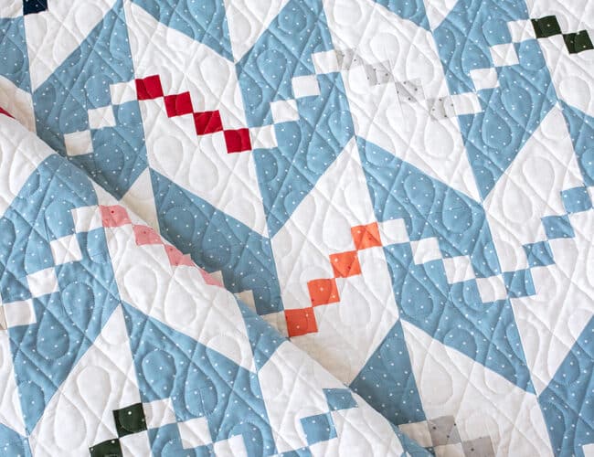 Persnickety knit herringbone quilt pattern in Magic Dot fabric by Lella Boutique for Moda Fabrics. Make it with a Layer Cake or charm packs. Download the PDF here!