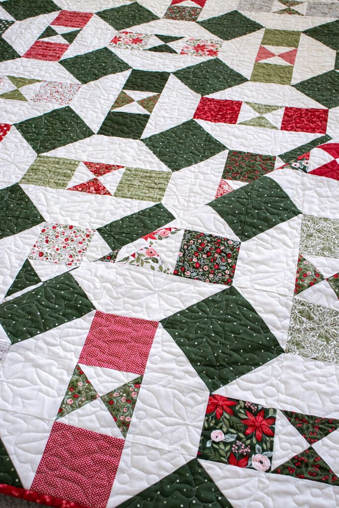 The "Somersault" charm pack quilt from the Charm School book by Vanessa Goertzen of Lella Boutique. Looks like a Christmas ornament quilt In Berry & Pine fabric.