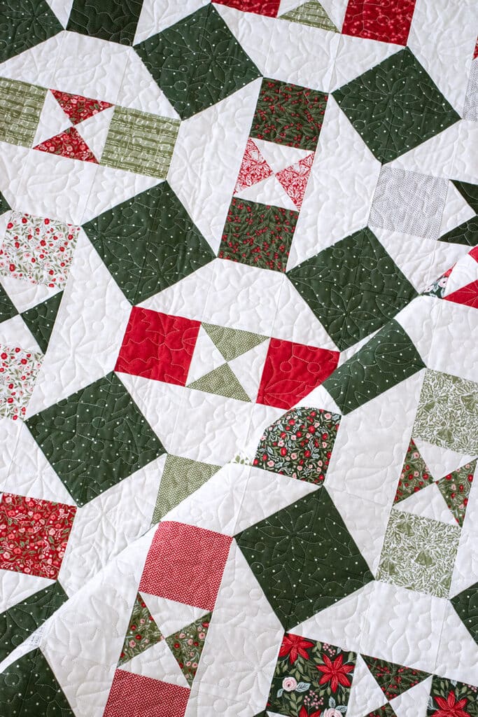 The "Somersault" charm pack quilt from the Charm School book by Vanessa Goertzen of Lella Boutique. Looks like a Christmas ornament quilt In Berry & Pine fabric.