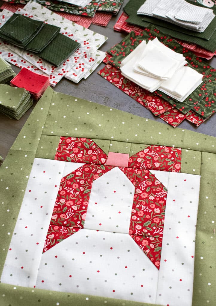 "Wrap it Up" gift quilt in Berry & Pine fabric by Lella Boutique. Make it with fat quarters and fat eighths. The wonky Christmas present blocks get their offkilter look from a beginner partial-seam technique. Download the PDF here.