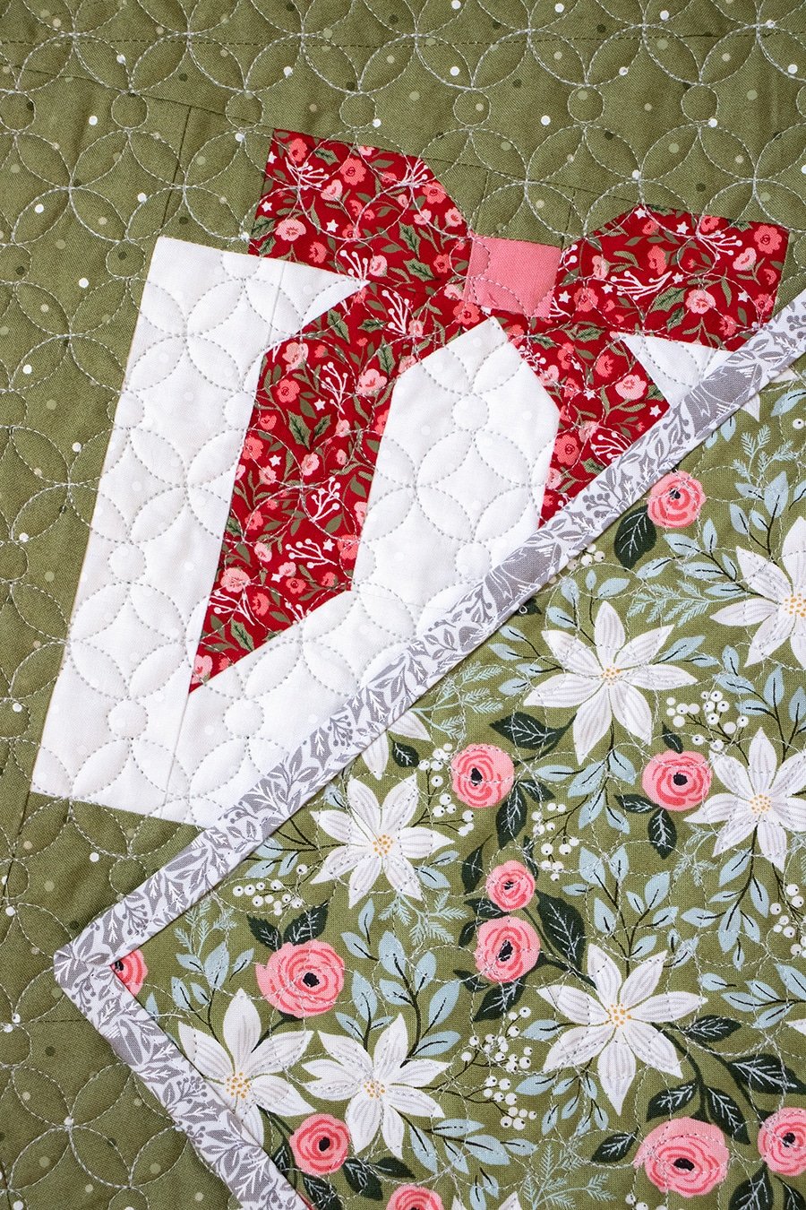 "Wrap it Up" wonky gift quilt in Berry & Pine fabric by Lella Boutique. Make it with fat quarters and fat eighths. The wonky Christmas present blocks get their offkilter look from a beginner partial-seam technique. Download the PDF here.