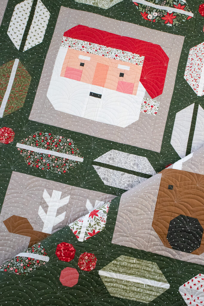 "Christmas Crew" Santa and reindeer quilt with cute holly and berry sashing by Lella Boutique. Jelly Roll friendly, fabric is Berry & Pine by Lella Boutique for Moda Fabrics (May 2025). Download the PDF here!