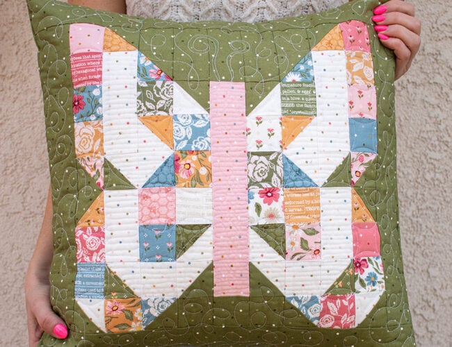 "Mini Charmed" scrappy butterfly pillow in Wild Honey Fabric. Make it with a mini charm pack. Download the PDF here!