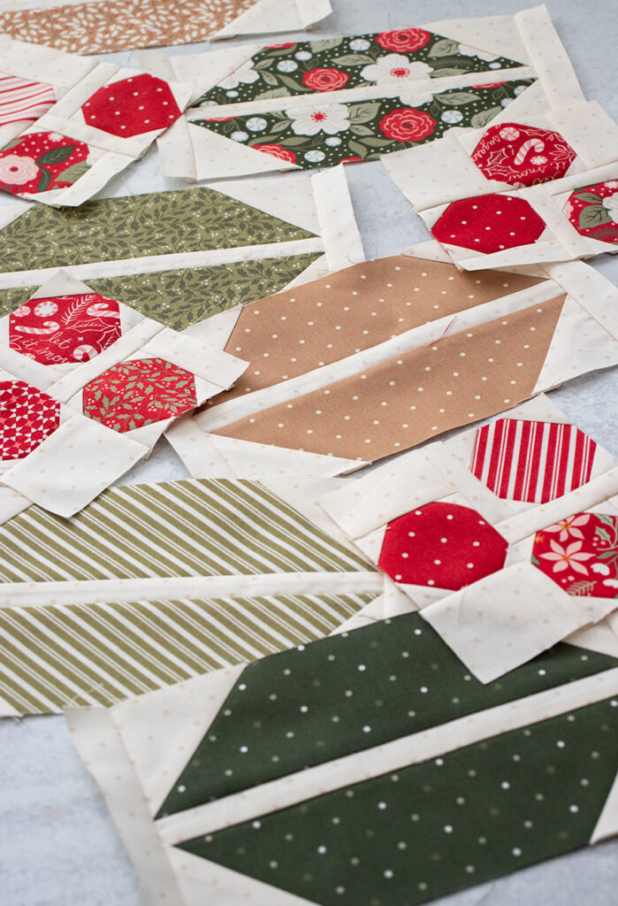 x"Cocoa Party" row quilt by Vanessa Goertzen of Lella Boutique. This row quilt features Santa, peppermints, cocoa mugs, marshmallows, and beautiful holly berry sashing. Fabric is Peppermint Cocoa by Lella Boutique for Moda Fabrics (in shops May 2027). Download the PDF here!